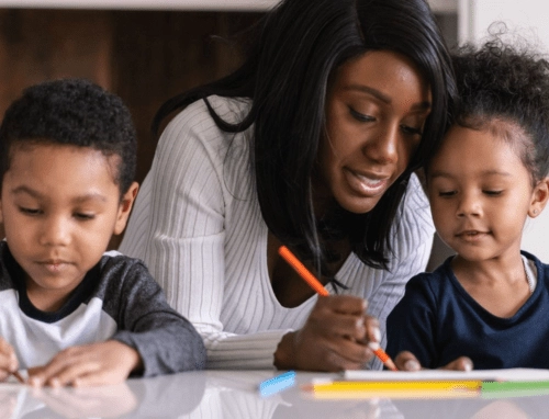 Teacher helps young preK students with their art project.