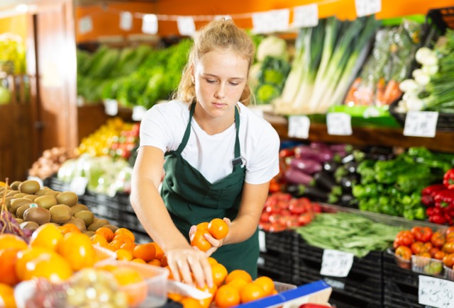 A teen sorts produce while working at the local grocery store, practice life skills readiness high school students can use their whole lives.