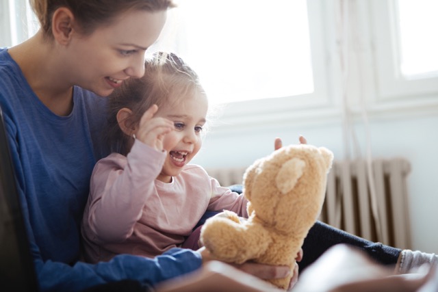 Mother playing with her young daughter at home
