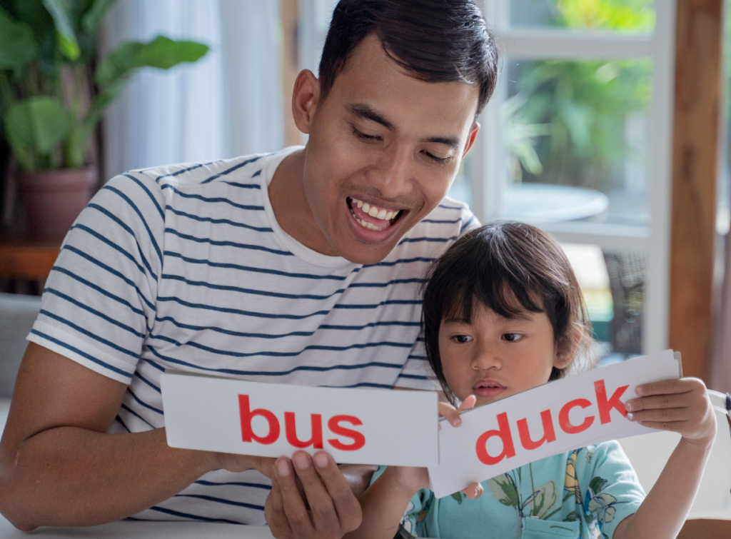 A young father practices new words with his toddler daughter.