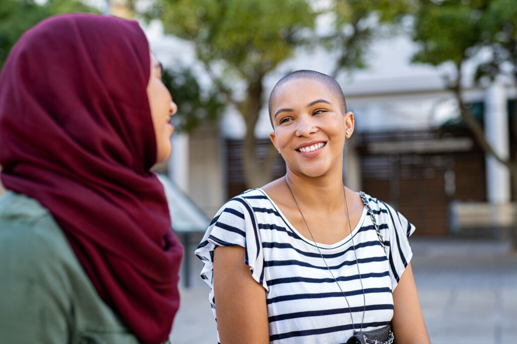 A group of multiethnic women walk and smile together on school campus.