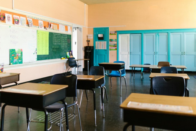 Image of empty desks in an elementary school classroom.